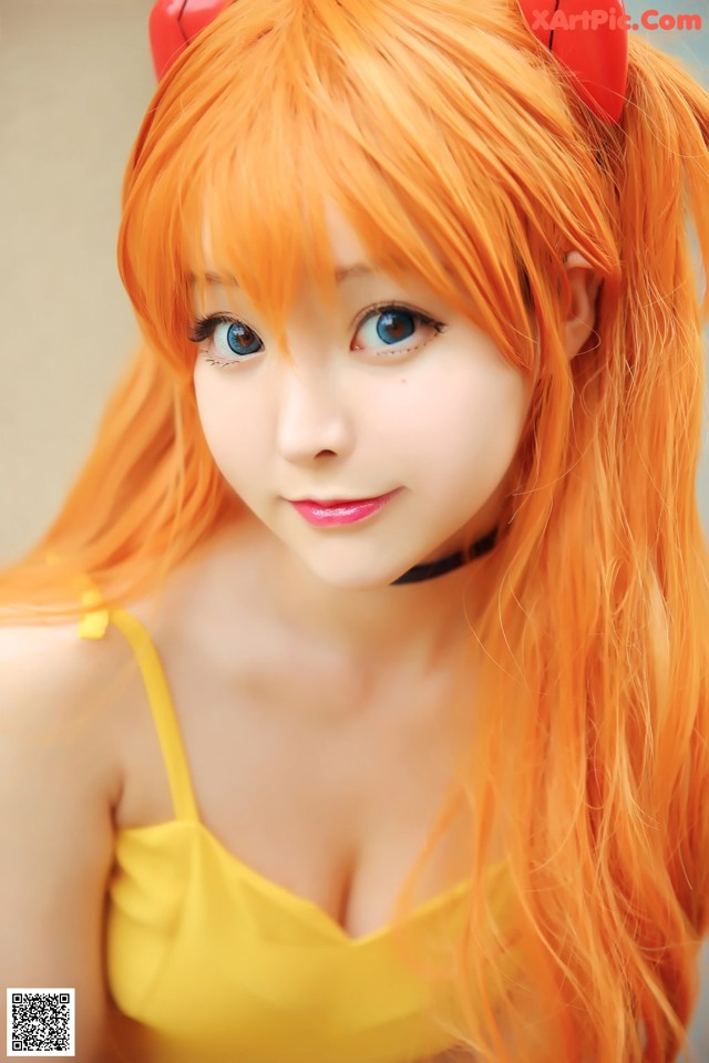 A woman with long orange hair wearing a yellow dress.