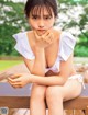 A woman in a white bikini sitting on a wooden bench.