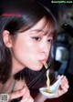 A woman eating a bowl of noodles with chopsticks.