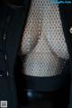 A close up of a woman wearing a black jacket and fishnet stockings.