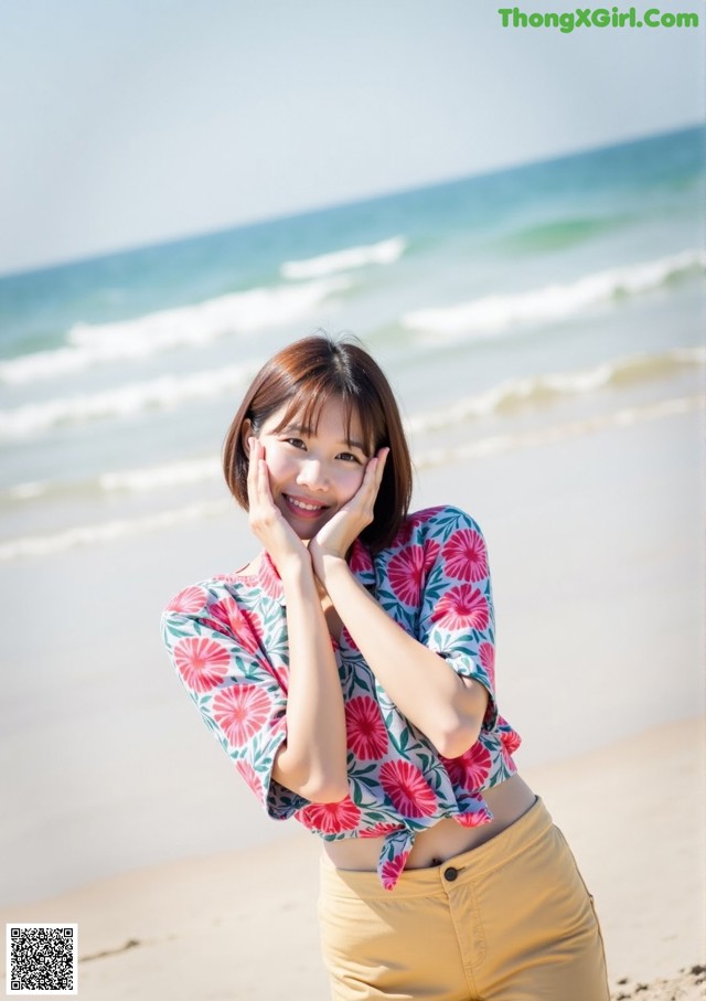 A woman standing on a beach next to the ocean.