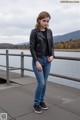 A woman standing on a pier next to a body of water.