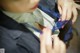 A woman in a business suit is tying up her tie.