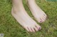 A woman's bare feet in the grass. 