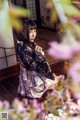 A woman in a kimono sitting on a wooden floor.