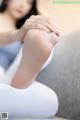 A woman sitting on a couch with her legs crossed.