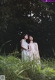 A couple of women standing next to each other in a field.