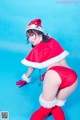 A woman in a santa claus outfit posing for a picture.