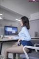 A woman sitting at a desk in front of a computer.