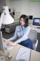 A woman sitting at a desk in front of a computer.