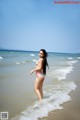 A woman in a bikini standing in the ocean.