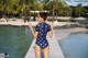 A woman in a polka dot swimsuit standing on a dock.