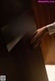 A woman's hand is touching the door handle of a hotel room.