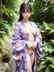 A woman in a purple kimono posing for the camera.