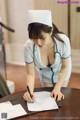 A woman in a nurse uniform writing on a piece of paper.