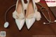 A pair of white wedding shoes and a stethoscope on a table.