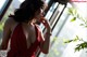 A woman in a red dress looking out a window.