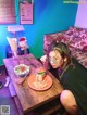 A woman sitting at a table with a plate of food.