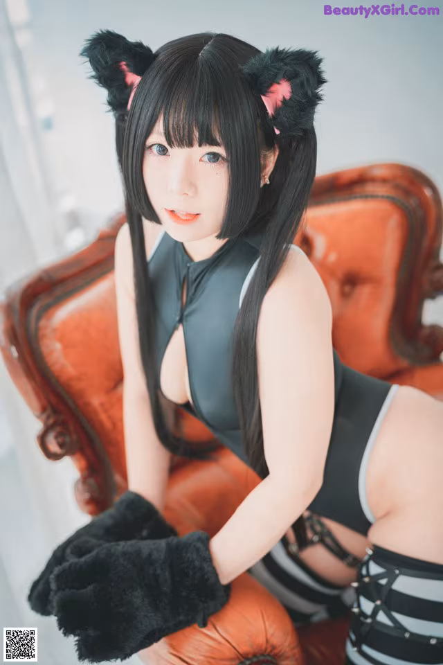 A woman in a cat costume sitting on a chair.