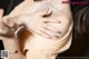 A close up of a woman's breasts with a bracelet on her wrist.