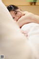 A woman laying in bed with her head on a pillow.